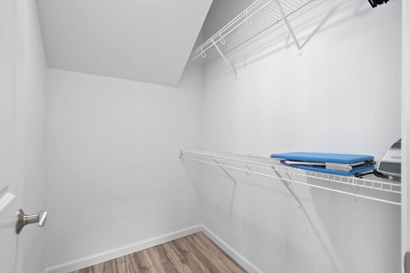 A small, white closet with a metal drying rack and a blue storage box. - Mauna View by Avantstay 10min to Beach, Backyard (Waianae)