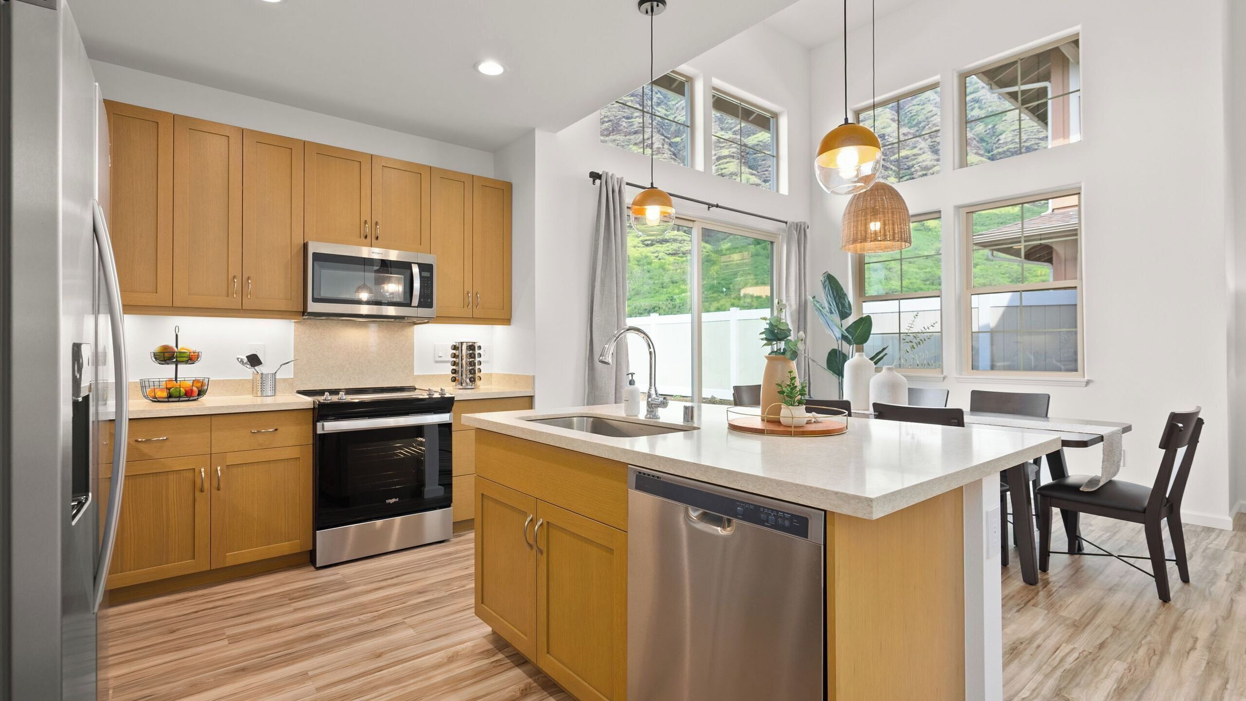 A modern kitchen with wooden cabinets, stainless steel appliances, a dishwasher, and a large island with a sink.