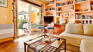 Ein gemütliches Wohnzimmer mit einer Couch, einem Couchtisch und einem Bücherregal voller Bücher.