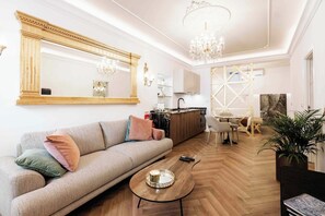 Ein modernes Wohnzimmer mit einer Couch, einem Couchtisch und einem großen Spiegel.