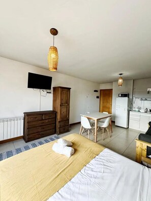Cozy retreat with a single bed, kitchenette, and dining area.