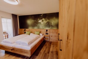 A bedroom with a wooden bed, a nightstand, and a wall-mounted lamp. - Schiebenrothenhof (Simonswald)