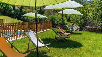 Een zwembadgedeelte met ligbedden en parasols.