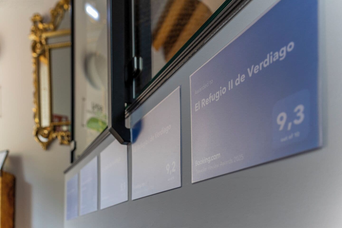 A wall with framed certificates and a mirror.