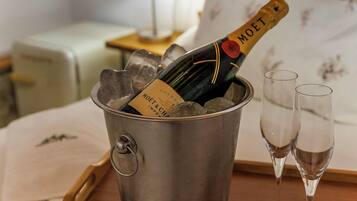 Un balde metálico con una botella de Moët champagne y dos copas sobre una bandeja de madera.