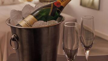 A minibar with a bottle of Moët champagne, ice cubes, and two empty wine glasses on a wooden table.