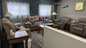 A living room with leather sofas, a coffee table, and a rug. - The Trailway Hub, ideally located in Deer Lake, 10 minutes from the airport (Deer Lake)