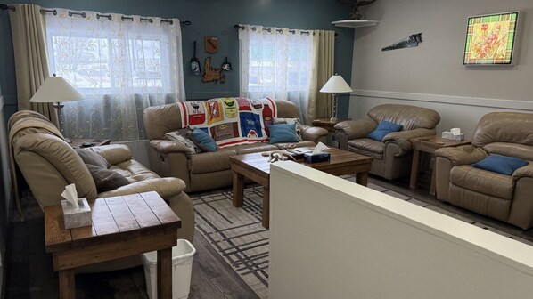 A living room with leather sofas, a coffee table, and a rug.