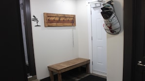 A hallway with a wooden bench, a coat rack, and a door. - The Trailway Hub, ideally located in Deer Lake, 10 minutes from the airport (Deer Lake)