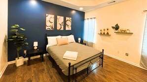 A bedroom with a bed, bedside tables, a potted plant, artwork on the wall, and a window with curtains. - Charming 3-bedroom cottage in gorgeous Oxford  (Oxford)
