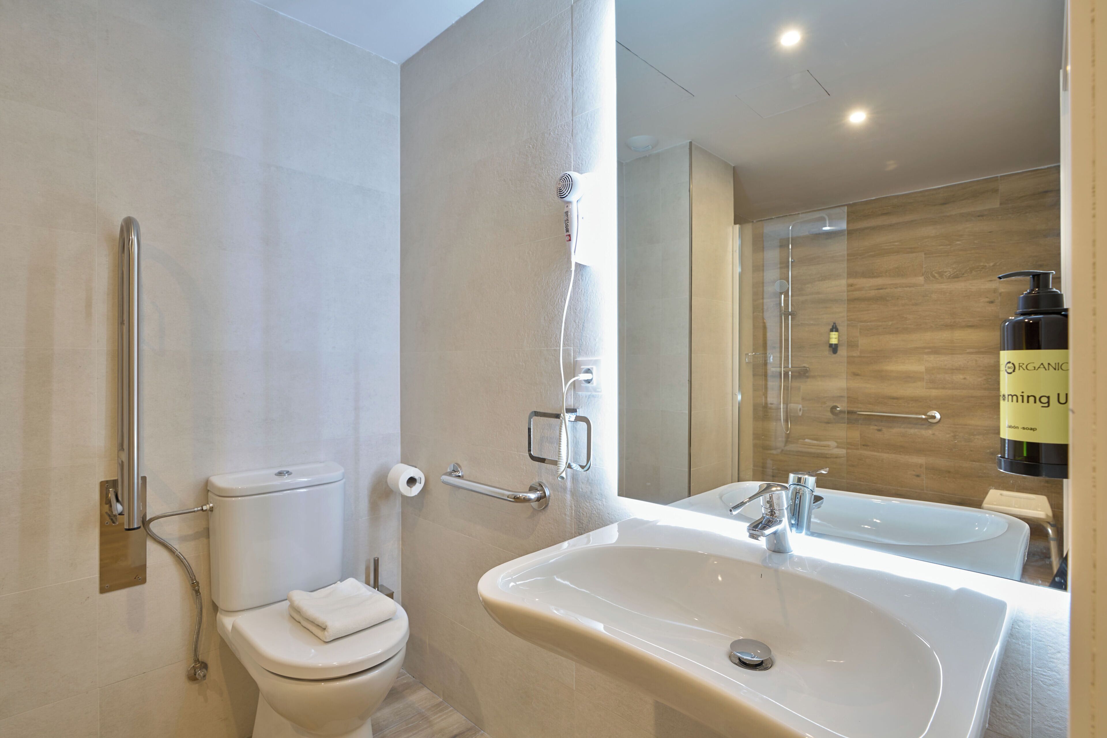 A modern bathroom with a toilet, a shower, and a sink.