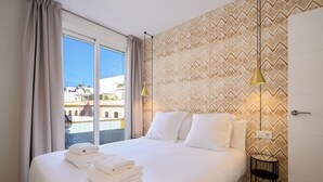 Camera d'albergo con un letto, un comodino, una lampada e vista sull'esterno.
