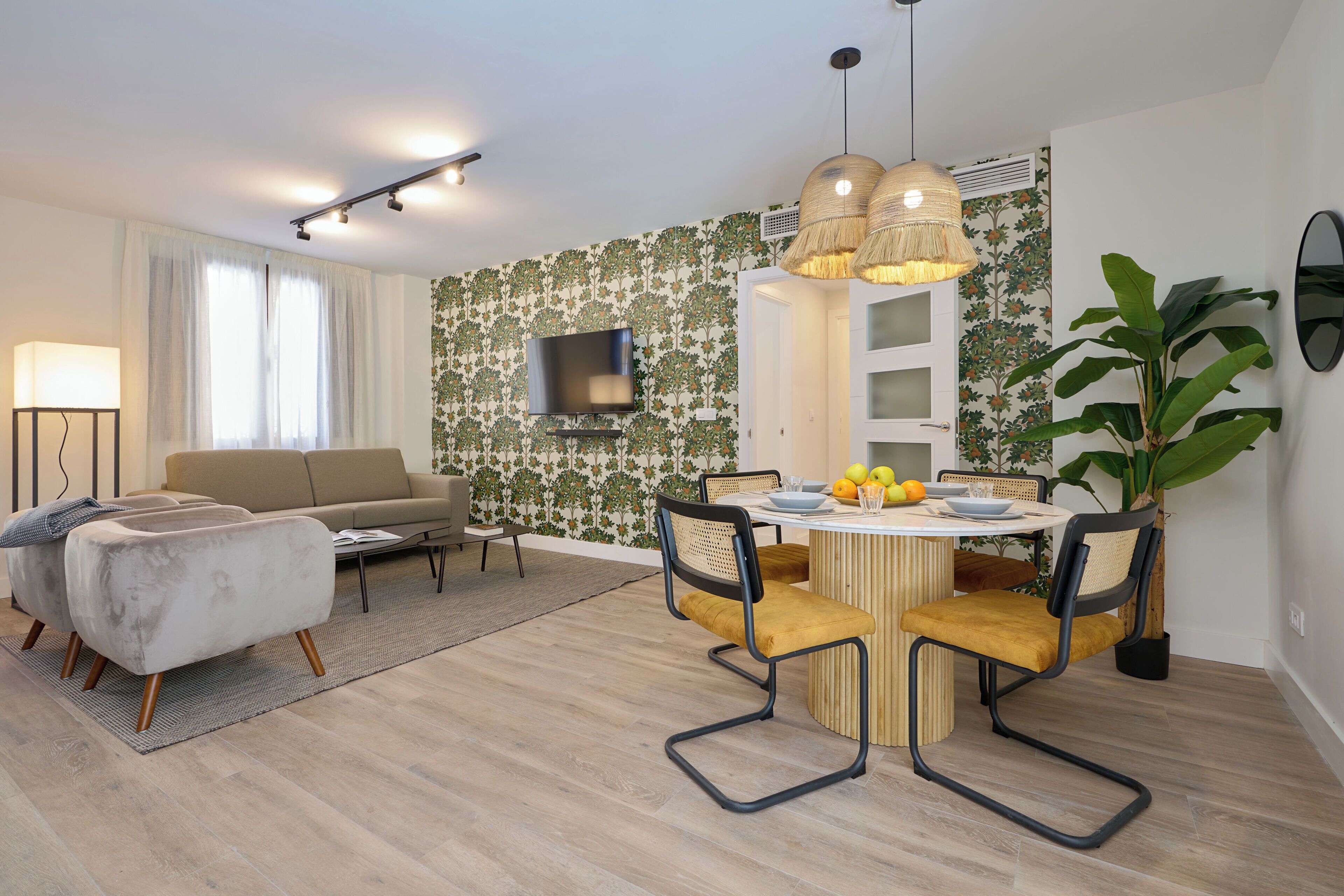 Ein modernes Wohnzimmer mit einer Couch, einem Couchtisch und einem Essbereich mit Stühlen und einem Tisch.