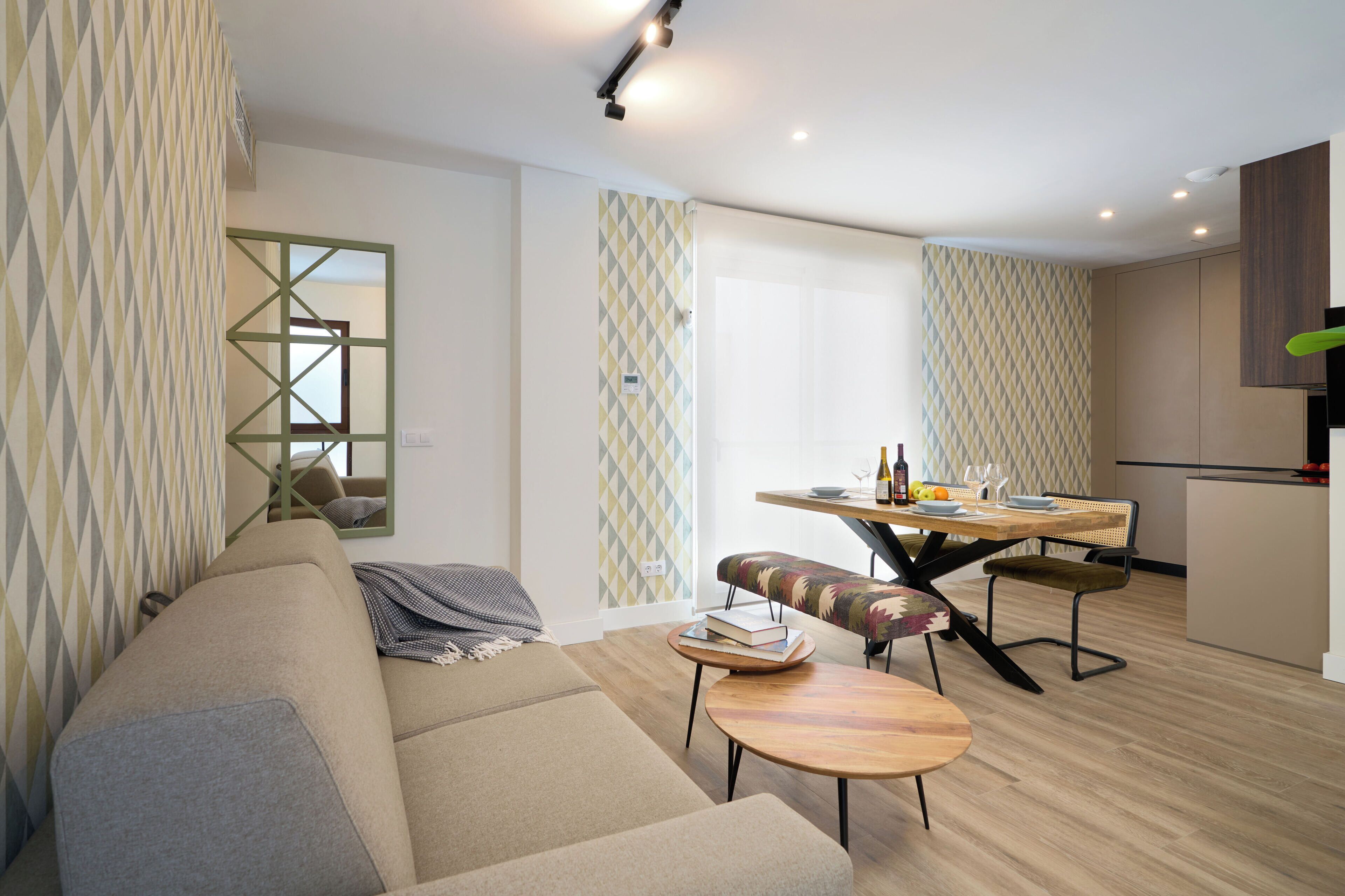Uma sala de estar moderna com um sofá, uma mesa redonda pequena e um espaço de jantar com cadeiras.