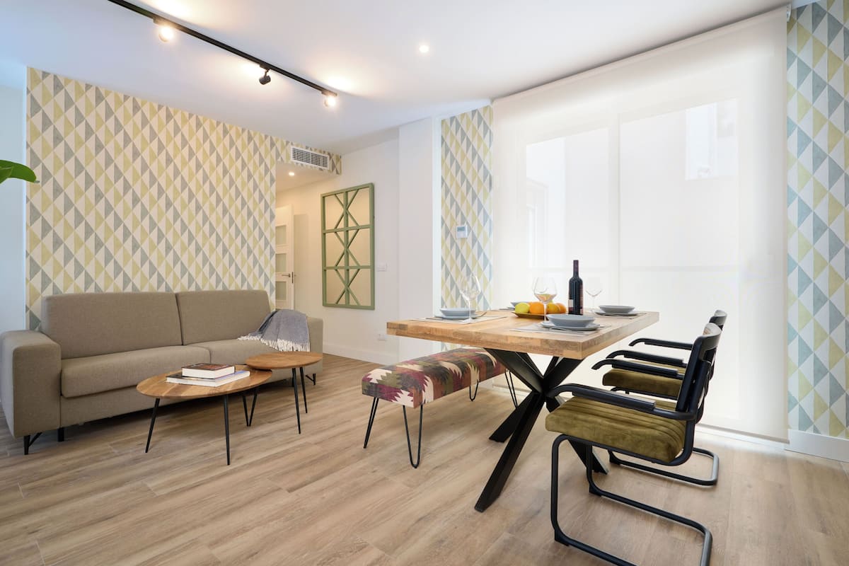 Un salon moderne comprenant un canapé, une table basse et une table à manger avec des chaises.