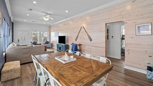 Un salon moderne avec une table à manger en bois, un canapé et un téléviseur.