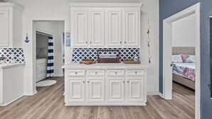 A kitchen with white cabinetry, a blue and white patterned backsplash, and a sign that reads "STAY AWAY." - HUGE DECK-1 Block to Sand, Sleeps 9, Lots of Parking & Early Access (Galveston)