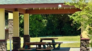 Eine Terrass mit Picknicktischen und einer Steinsäule.