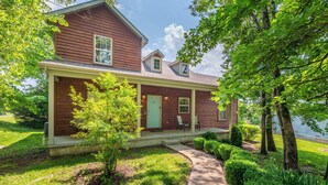 A two-story house with a covered porch, a front door, and a small front yard with a pathway leading to the door. - Hickory Hideaway w/ Communal Pool Access (Hollister)
