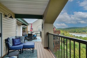 A covered outdoor area with a sofa, chairs, and a table. - Table Rock Lookout Duo | Spacious Balcony (Branson)