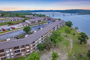 A multi-story hotel with a parking lot and a view of a bridge over a river. - Lakefront Oasis – Amazing Views! (Kimberling City)