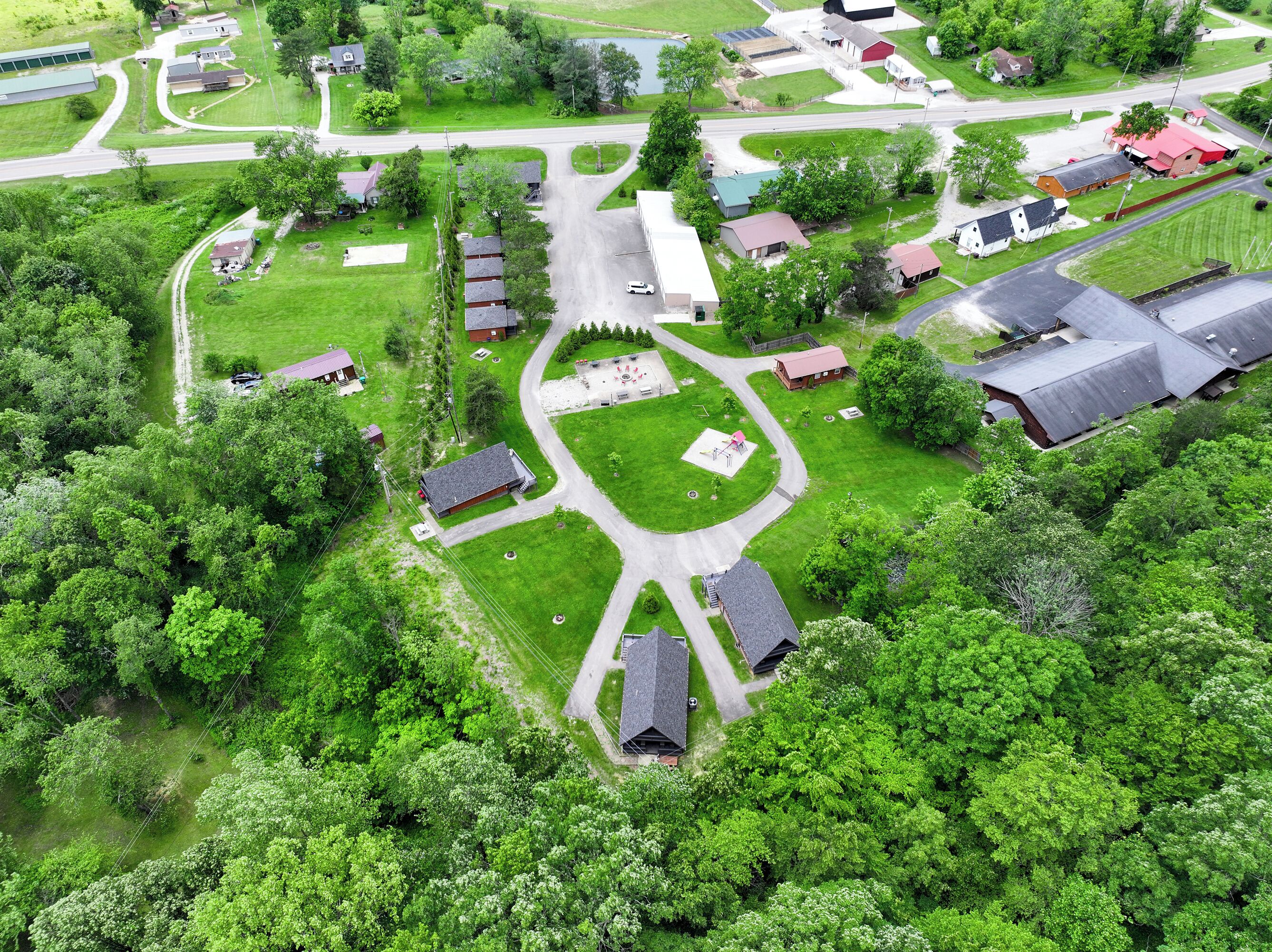 An aerial view of a residential area with houses, roads, and green spaces.