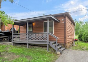 Une petite cabane avec une véranda, une porte et une fenêtre.