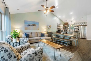 A living room with a sofa, coffee table, and dining table.