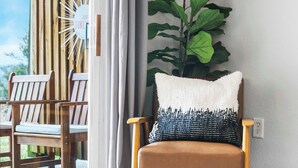 A room with a wooden chair, a large plant, and a wall-mounted light fixture. - Family-Friendly Retreat – Enviable Location! (Branson)