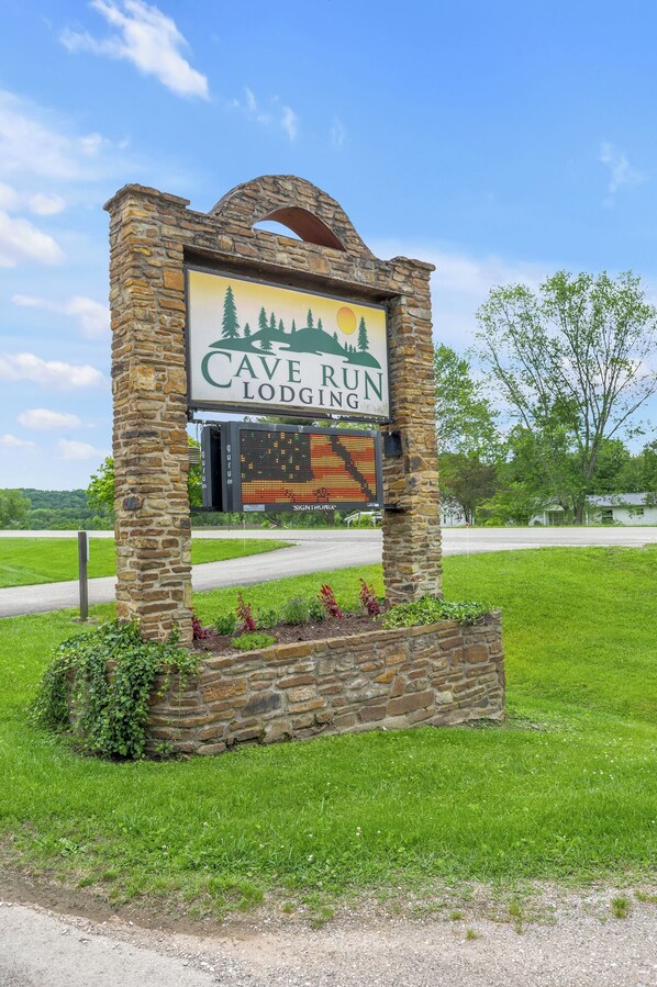 A stone sign for Cave Run Lodging with a digital display below.