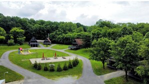 Ein Park mit Spielgeräten, Picknicktischen und einem Wanderweg.