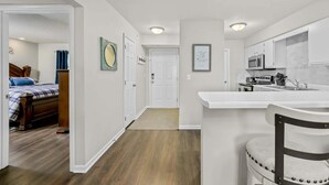 Un appartement compact comprenant une chambre, une kitchenette et une salle de bain.