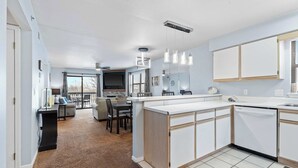 Una cocina moderna con armarios blancos, una isla central e iluminación colgante.