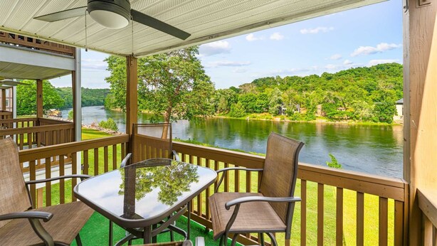 A covered outdoor area with a table and chairs, overlooking a river and forested hills. - On Lake Time Taneycomo - Amazing Views (Branson)