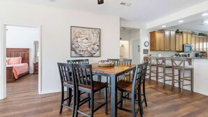 A spacious dining area with a wooden table and chairs, a ceiling fan, and a kitchen area with wooden cabinets and a microwave. - Lakefront Sanctuary II at Indian Point (Branson)