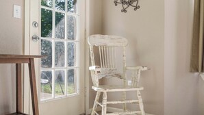 A room with a white wooden chair, a wooden table, and a window with a view of greenery outside. - Holiday Ridge Escape | Holiday Hills Branson | Golf Resort | Outdoor pools (Branson)