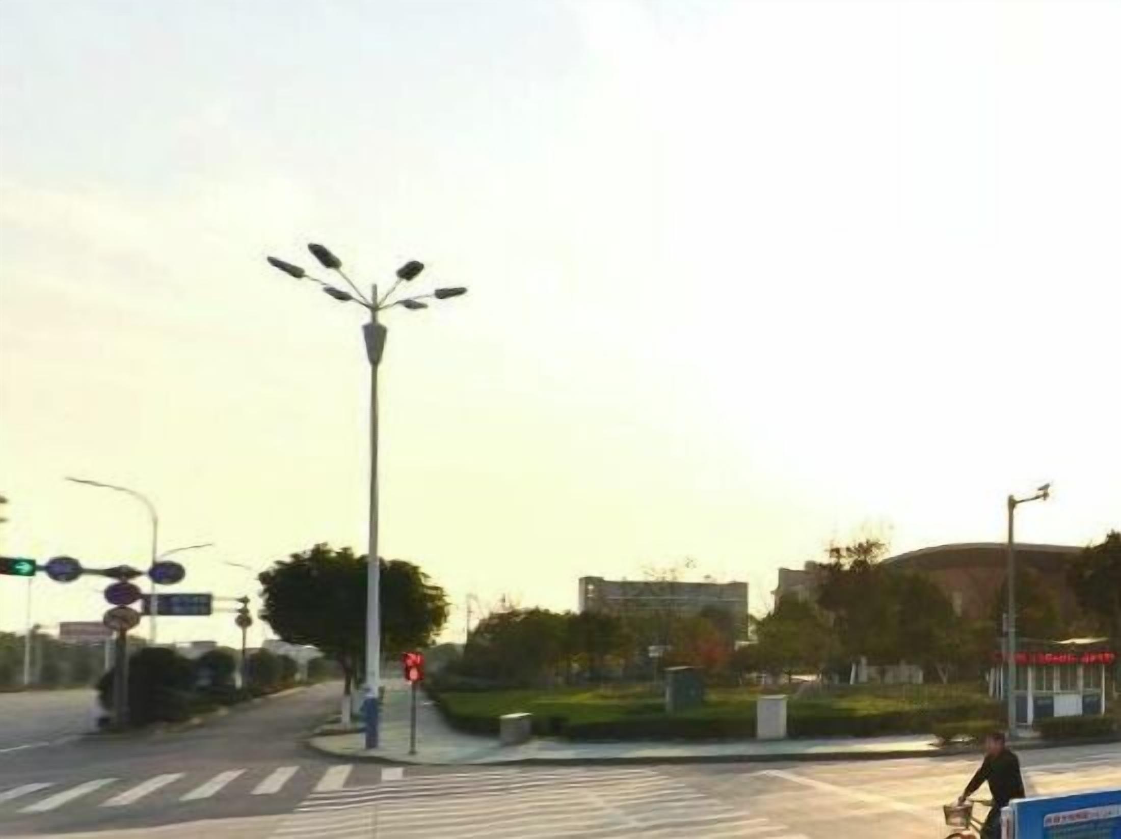 Une intersection avec des feux de signalisation, un passage piéton et une personne qui pousse un chariot.