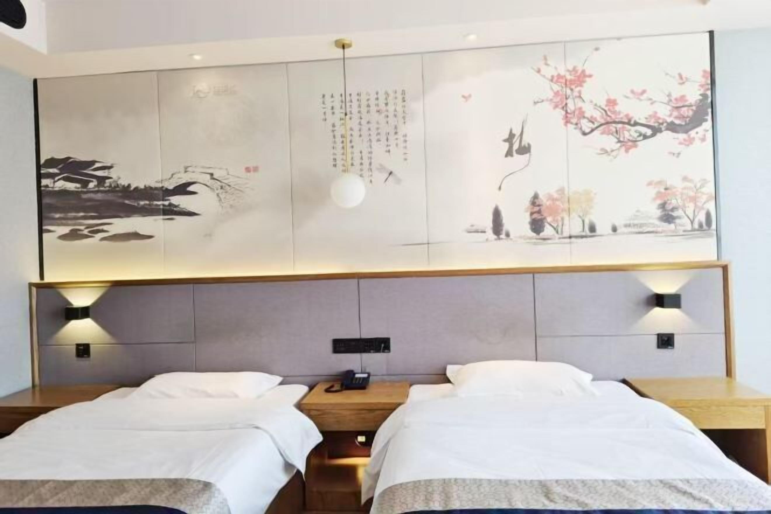 A hotel room with two beds, a large artwork on the wall, and a modern light fixture.