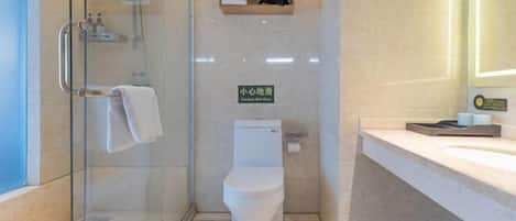 Une salle de bain moderne avec une douche à parois de verre, des toilettes, un lavabo et un porte-serviettes.