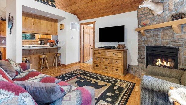 Ein gemütliches Wohnzimmer mit Kamin, Steinwand und Holzboden.