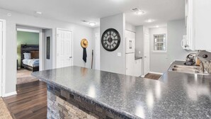 A modern kitchen with granite countertops, a built-in oven, and a stainless steel sink.