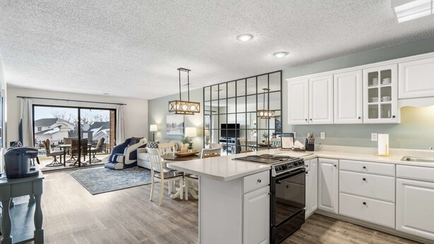 Una cocina moderna con armarios blancos, una isla grande y un comedor con vistas.