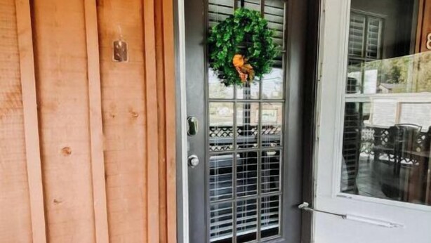 A wooden exterior with a gray door, a deer head decoration, a wreath, and a welcome mat. - Cave Run Lodge Near Lake & Marina Cabin Suite #8 (Morehead)