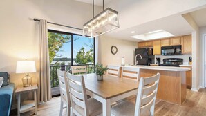 A modern kitchen with wooden cabinets, a black refrigerator, and a microwave. - Lakeview At Table Rock (Kimberling City)
