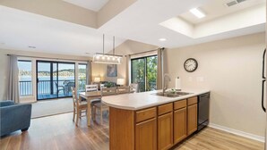 A spacious kitchen with a large island, a dining area with a view, and a balcony. - Lakeview At Table Rock (Kimberling City)