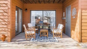 A wooden building with a covered patio, a glass door, and a tree-shaped decoration. - Pointe Royale Retreat | Relaxation Awaits! (Branson)