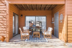 Enjoy a relaxing outdoor space with a covered patio, glass door, and comfortable seating for four.