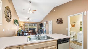 A kitchen with a dishwasher, a ceiling fan, and a view into the dining area. - Stunning Water View – Pet Friendly, Indoor Pool (Branson)