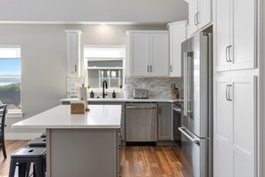 Una cocina moderna con armarios blancos, electrodomésticos de acero inoxidable y una isla grande.