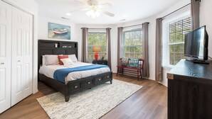 A bedroom with a bed, a ceiling fan, a TV, and a window with curtains. - Boatin & Floatin on Table Rock Lake in the Ozarks! (Kimberling City)